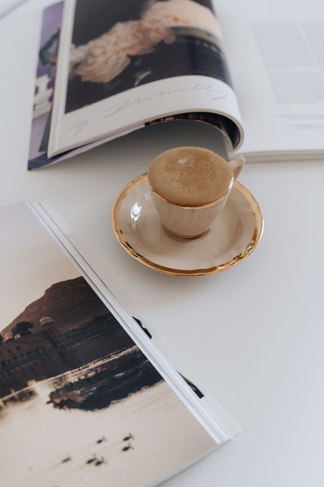 A coffee cup beside an open magazine