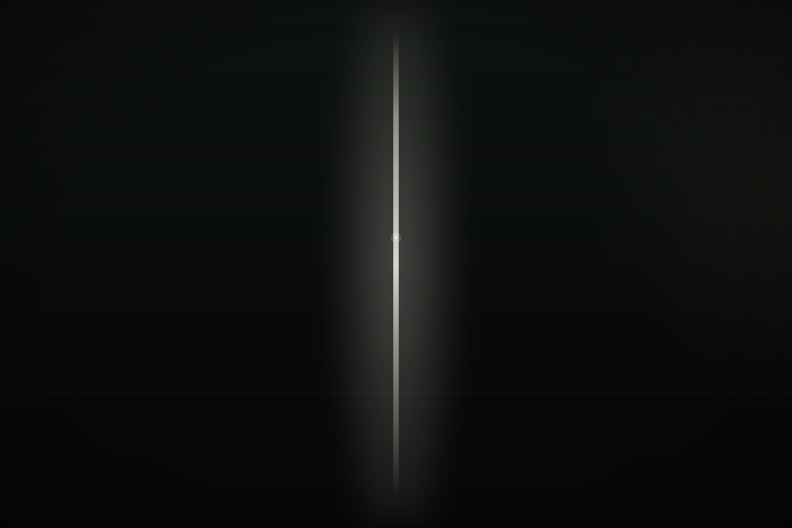 A single column of warm light held in a dark room